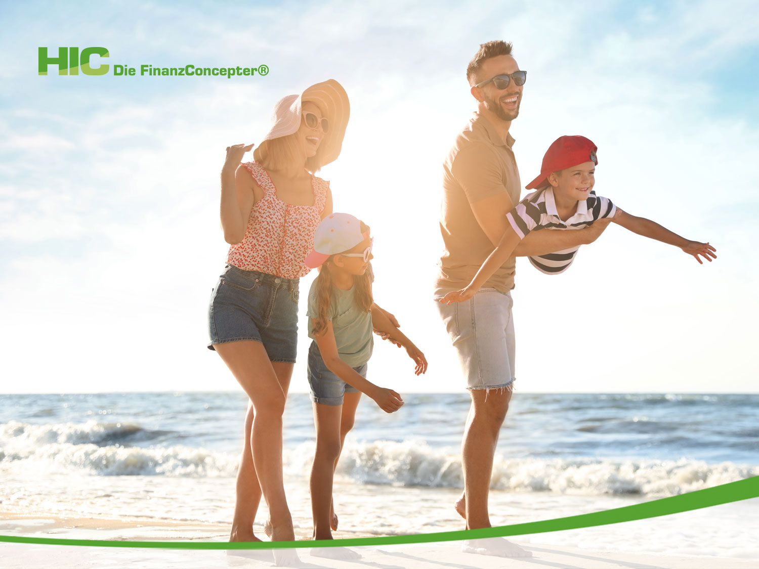 junge Familie mit zwei Kindern läuft an einem sommerlichen Strand entlang und hat Spaß